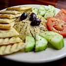 Plate with vegetables, hummus and pita bread. 