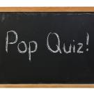 Pop quiz written on a blackboard with white chalk