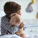child holding a stuffed bear
