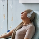 Patient in hospital listening to music and smiling