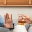 Person refusing a glass of alcohol