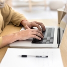 older woman typing on computer
