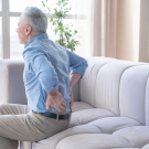 elderly man clutching lower back