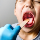 Child opening mouth to display tonsils. 