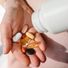 Person pouring various pills into hand