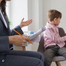 Child with ADHD distracted as a clinician speaks to him.