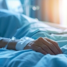 Person lying in hospital bed.