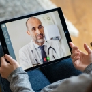 Patient speaking to a doctor via telecare on a tablet device