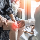 Person clutching their knee in pain