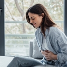Person clutching abdomen in pain