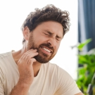 Person clutching jaw because of tooth pain