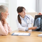 clinician showing patient lung imaging