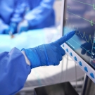 gloved finger pointing at heart monitor during surgery