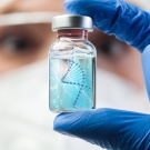 Doctor holding up a vial with an illustration of DNA inside
