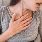 Woman coughing and clutching her chest