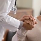 physician helping patient holding hands