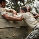 military personnel climbing a wall during basic training 