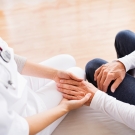 physician holding elderly patient's hand