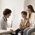 doctor speaking to a male pediatric patient and mother
