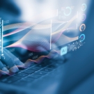 hands at a computer using AI