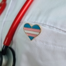trans flag pin on doctor coat