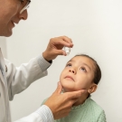 child getting eye drops