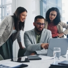 group of young professionals around a computer
