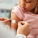 little girl getting bandaid on arm
