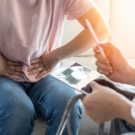 patient touching stomach talking to doctor