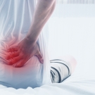 man gripping back in pain