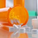 pills spilling out of a tipped over pill bottle