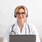 doctor with headphones at her laptop