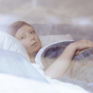 woman lying in hospital bed + cancer + hospice care