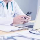 physician at desk with phone