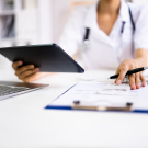 physician with charts at computer