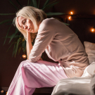 woman sitting on edge of bed