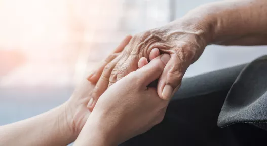 older patient hands holding younger hands