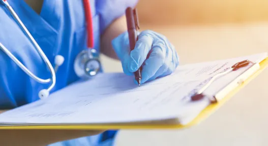 doctor writing on chart