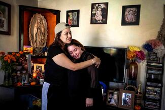 Camerina Ron de Buenrostro is comforted by Perla Mendoza next to an altar Ron de Buenrostro keeps in her Watts home in memory of her daughter Amy, who died of a fentanyl overdose at age 21 and was found in an abandoned building after months of reporting her missing. Mendoza, of Seal Beach, also lost her son Elijah, 20, to fentanyl. The altar became an ofrenda for Día de los Muertos. (Photo by Sarah Reingewirtz, Los Angeles Daily News/SCNG)