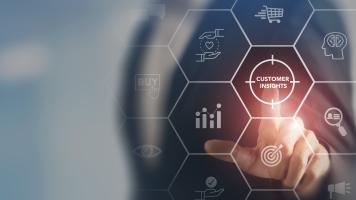Businessman in suit pointing to digital illustration of business icons.