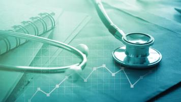A stethoscope on a file folder with a line graph superimposed over the image.