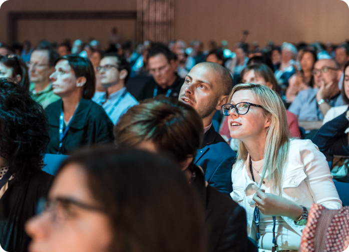 Attendees listening in a session room at an HMP Global conference