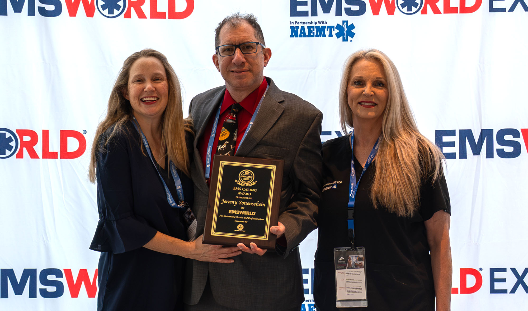 Award recipients in front of a step and repeat banner