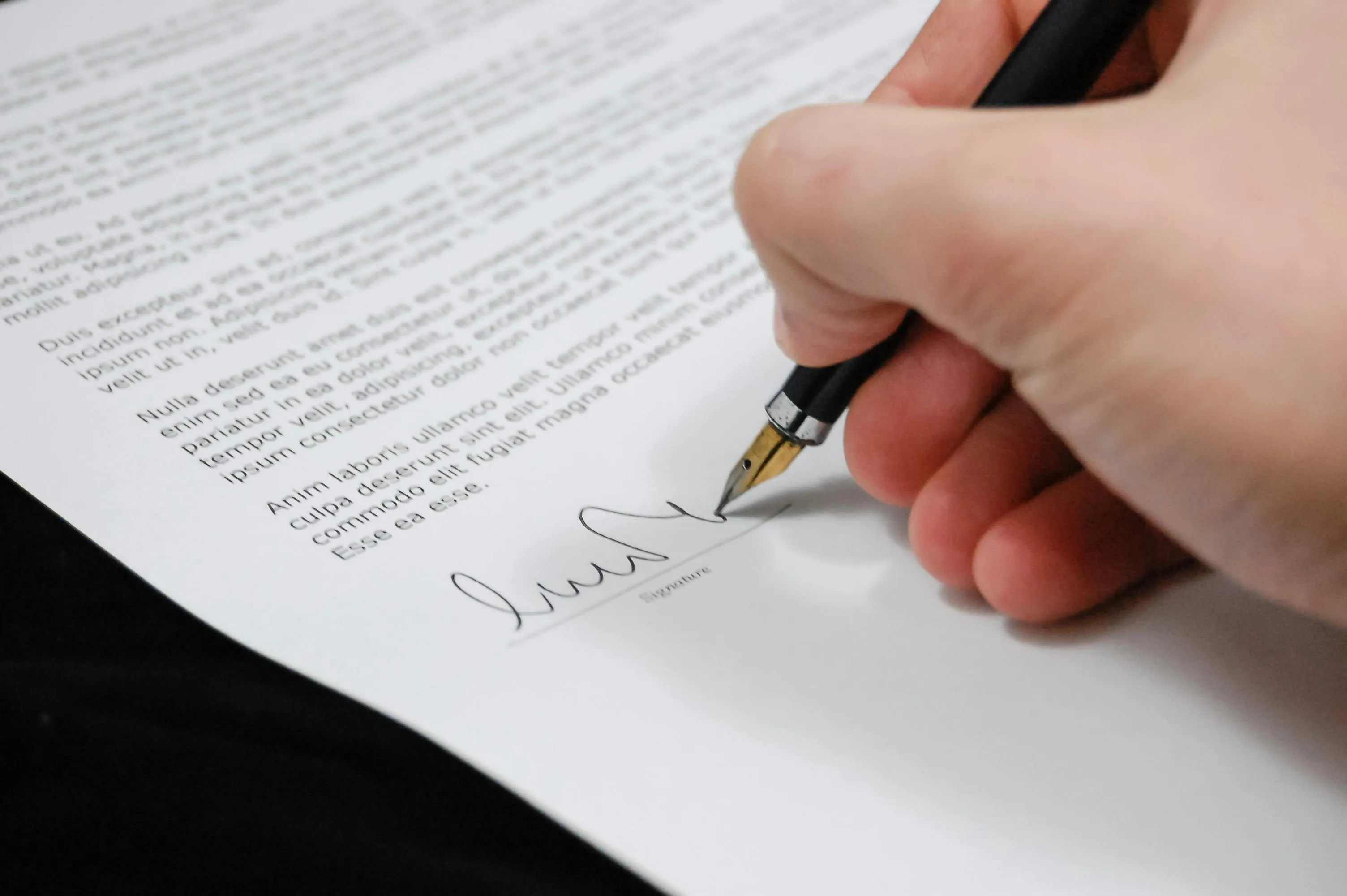 Close-up of document being signed.