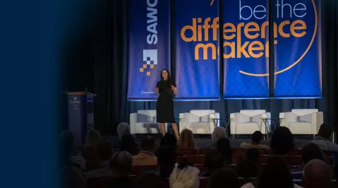 Image of Suzanne Moloney on stage, past keynote speaker at SAWC Fall, sharing her journey in wound care innovation.