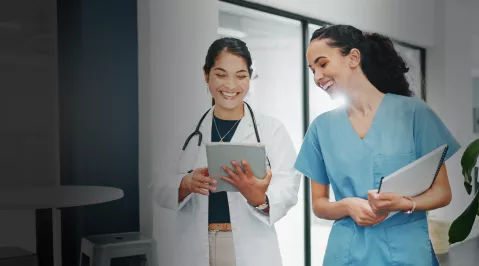 An image of two healthcare professionals collaborating and reviewing medical info. 