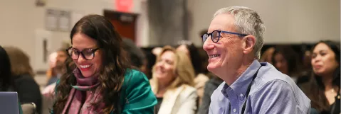 Attendees smiling in audience